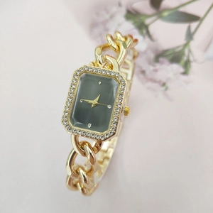 Close-up of gold chain bracelet watch with rectangular green dial and rhinestone bezel