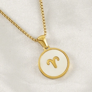Detailed macro view of an 18K gold Aries constellation pendant with white shell inlay