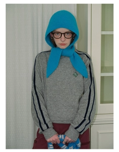 Detail of blue knitted hooded scarf paired with a grey long-sleeved crewneck sweatshirt