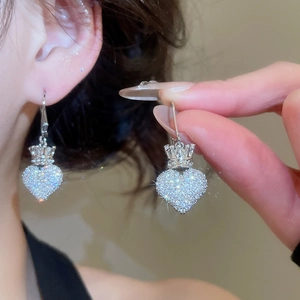 Detail shot of heart crown earrings with zircon pavé setting on a model's ear