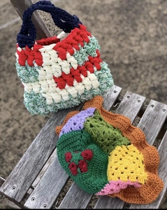 Close-up of handmade crochet bag set with colorful patchwork on a wooden bench