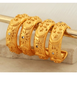 Detail of bohemian gold hoop earrings with sculpted sun and moon relief patterns