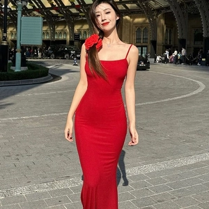 Close-up of a red slim-fit sleeveless maxi dress with elegant flower accessories on a model