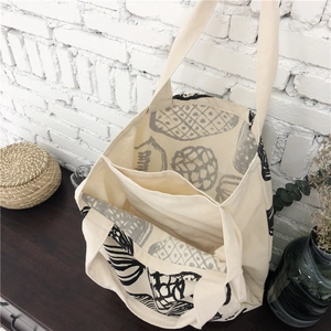 Canvas tote bag with pineapple print and multiple compartments on wooden desk
