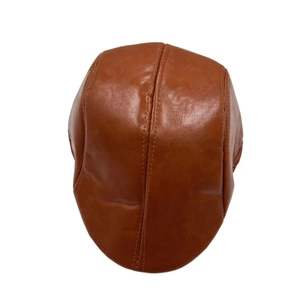 Close-up of brown PU leather flat cap showing detailed texture and stitching