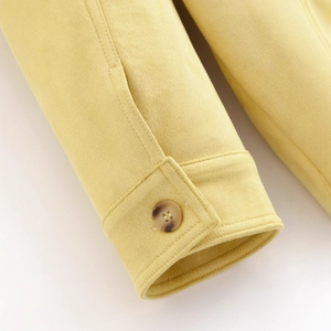 Close-up of mustard yellow faux suede jacket cuff with amber button detail
