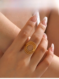 Close-up of golden triple-layered concentric ring with textured finish on a finger