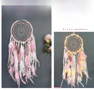 Detail of dream catcher with pink feathers and LED lights contrast in two different modes