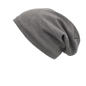 Detailed waffle knit texture of a medium grey slouchy beanie in a soft cotton blend
