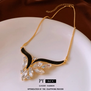 Vintage wing pendant necklace with black enamel and crystals on a gold snake chain