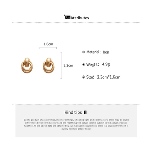 Vue détaillée des boucles d'oreilles créoles géométriques mates entrelacées avec mesures