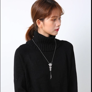 Elegant silver flower necklace with pearl petals and long tassels on black sweater