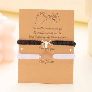 Detail of woven Halloween friendship bracelets with spider and web charms on display card