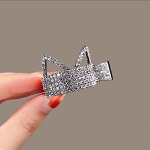 Detailed view of silver cat ear hair claw clip with sparkling rhinestone embellishments