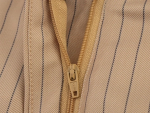 Macro shot of khaki striped linen blend fabric with matching nylon zipper detail