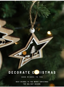 Detail of wooden Christmas ornaments with reindeer carving on a green tree branch