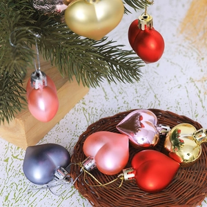 Detail of multi-colored heart-shaped Christmas ornaments on tree and in basket