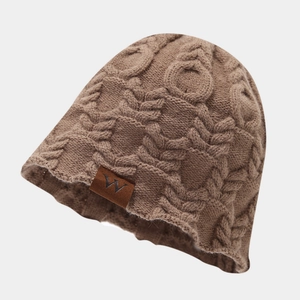 Détail du bonnet en maille torsadée marron avec texture épaisse et écusson en cuir
