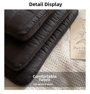 Detail showing black quilted polyester fabric and buffered edges of the laptop sleeve