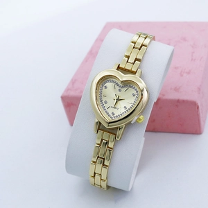 Close-up of heart-shaped gold quartz watch with rhinestones on a white display stand