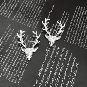 Broche bois de cerf argentée élégante sur fond noir de magazine pour accessoire de costume