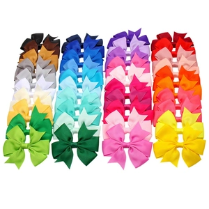 Detailed grid of assorted 4-inch velvet ribbon Christmas hair bows in vibrant multi-colors