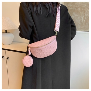 Detailed back view of pink woven crossbody bag set with patterned strap on female model