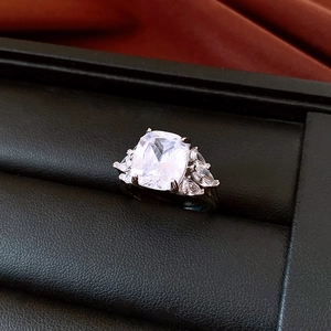 Macro shot of cushion-cut cubic zirconia ring with marquise side stones on black leather