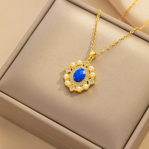 Elegant gold necklace with blue oval stone and pearls showcased in a jewelry gift box