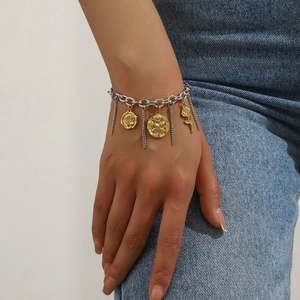 Detail of rose and coin pendants on a dual-tone gold and silver link bracelet