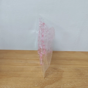 Pink transparent acrylic snowflake pendant inside a protective plastic poly bag