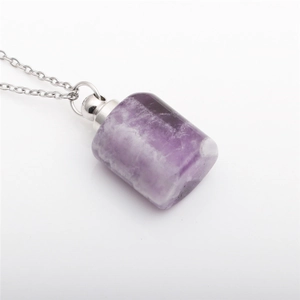 Detailed close-up of a purple amethyst essential oil bottle pendant on a silver chain