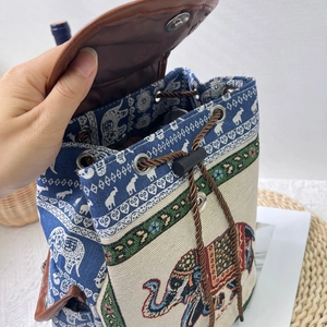 Detailed view of the drawstring closure and magnetic buckle on the ethnic elephant backpack