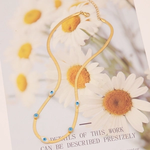 Collier chaîne serpent dorée avec breloques œil bleu sur carte florale