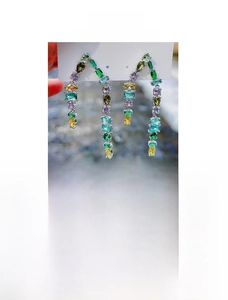 Détail des longues boucles d'oreilles en zircon coloré avec des dimensions géométriques