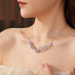 Close-up of pink zircon flower pendant necklace worn on a model for an elegant look