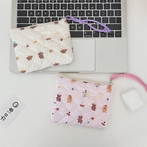 Detailed close-up of quilted floral cosmetic bags with cute dog and bear patterns