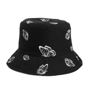 Gros plan du chapeau bob en toile de coton noir avec motifs de papillons blancs