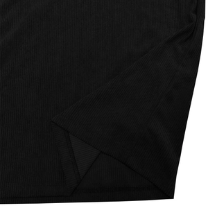 Close-up of black ribbed knit fabric showing side slit detail and fine stitching on polo shirt