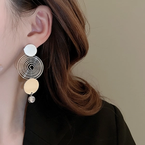 Detail of silver drop earrings with multi-layer circular rings and a crystal accent