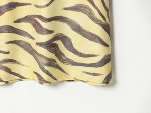 Macro view of warm yellow zebra print fabric with high-quality hem stitching detail