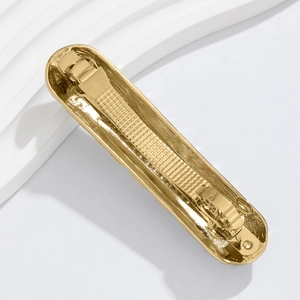 Detailed close-up of golden alloy hair clip showing durable spring mechanism and texture
