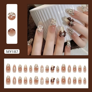 Bowknot cat-eye press-on nails with diamonds and pearl accents in a gradient nude style