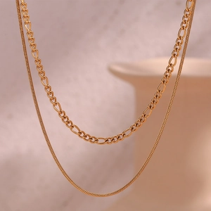 Macro detail of 18K gold-plated double-layer Figaro and snake chain texture on the necklace
