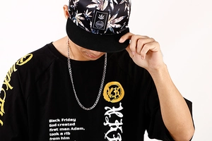 Détail de l'ensemble streetwear comprenant un t-shirt noir graphique et une casquette