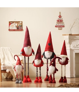 Plush Christmas gnomes in red, grey, and white arranged in a cozy festive home setting