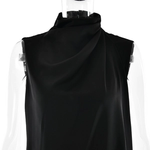 Close-up of black sleeveless mock neck top featuring asymmetric draped pleats on fabric