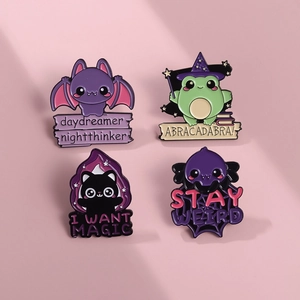 Detailed view of four fantasy cartoon enamel pins featuring a bat, frog, cat, and monster