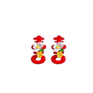 Red Xi character earrings with delicate floral accents on a clean white background