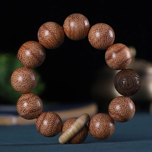 Gros plan de perles en bois d'agar d'Indonésie avec grain naturel et sculpture de pièce